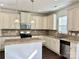 Well-lit kitchen features granite counters, stainless steel appliances, island, and stylish tile backsplash at 1019 Dunhill Ln, Waxhaw, NC 28173