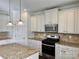 Spacious kitchen with stainless steel appliances, granite counters, tiled backsplash, and an island at 1019 Dunhill Ln, Waxhaw, NC 28173