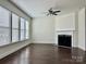 Cozy living room with dark hardwood floors, a ceiling fan, and a fireplace at 1019 Dunhill Ln, Waxhaw, NC 28173