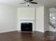 Cozy living room with dark hardwood floors, a ceiling fan, and a fireplace at 1019 Dunhill Ln, Waxhaw, NC 28173