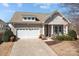 Charming home with a two-car garage, covered porch with rocking chairs, and well-maintained landscaping at 113 Artisan Ct, Mooresville, NC 28117
