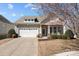 Charming home with a two-car garage, covered porch with rocking chairs, and well-maintained landscaping at 113 Artisan Ct, Mooresville, NC 28117