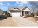 Charming home with a two-car garage, covered porch with rocking chairs, and well-maintained landscaping at 113 Artisan Ct, Mooresville, NC 28117