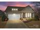 Charming home with a two-car garage, covered porch with rocking chairs, and well-maintained landscaping at 113 Artisan Ct, Mooresville, NC 28117