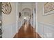 Inviting hallway with hardwood floors, white wainscoting and arched doorways leading to other rooms at 113 Artisan Ct, Mooresville, NC 28117