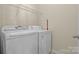 Functional laundry room with white washer and dryer and wire shelving at 113 Artisan Ct, Mooresville, NC 28117