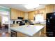 Well-lit kitchen with black appliances, wood cabinets, and a central island with a breakfast bar at 118 Sunset Dr, Chester, SC 29706