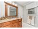 Bathroom featuring vanity with tan counters, sink, wood cabinets, and tiled shower at 11924 Parks Farm Ln, Charlotte, NC 28277