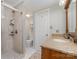 Bathroom featuring tiled shower and vanity with a stone countertop, sink, and wood cabinets at 11924 Parks Farm Ln, Charlotte, NC 28277