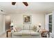 Cozy living room with a ceiling fan, comfortable sofa, and a view to the backyard at 11924 Parks Farm Ln, Charlotte, NC 28277