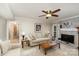 Comfortable living room featuring a fireplace, ceiling fan, and neutral-toned furniture at 11924 Parks Farm Ln, Charlotte, NC 28277