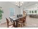 Comfortable dining room with a wooden table and chairs, complemented by modern lighting and backyard views at 122 Tillery Ln # 759P, Mount Gilead, NC 27306