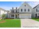 Charming two-story home with a manicured lawn, two-car garage, and a modern farmhouse-style exterior at 122 Tillery Ln # 759P, Mount Gilead, NC 27306