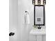 Stylish pedestal sink in bathroom with black fixtures, modern lighting, and fresh white walls at 13110 Blacksmith Ct, Matthews, NC 28105