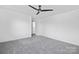 This carpeted bedroom features a ceiling fan and neutral decor at 13110 Blacksmith Ct, Matthews, NC 28105