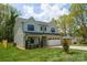 Light blue two-story home with a brick-accented garage, green yard, and a beautiful landscape at 13110 Blacksmith Ct, Matthews, NC 28105