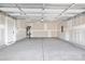 Spacious unfinished garage with concrete floors, drywall, and a modern roll-up door at 13110 Blacksmith Ct, Matthews, NC 28105