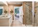 Well-lit bathroom featuring a double vanity, granite countertops, and a separate glass-enclosed shower at 147 Colonial Reserve Ave, Troutman, NC 28166
