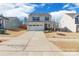 Charming two-story home featuring a wide driveway, attached garage, and manicured landscaping at 147 Colonial Reserve Ave, Troutman, NC 28166