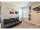 Relaxing living room area featuring a gray futon, wall art, neutral carpet, and a window at 147 Colonial Reserve Ave, Troutman, NC 28166