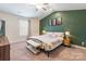 Bedroom with ceiling fan, bed with throw blanket, side tables, and a green accent wall at 147 Colonial Reserve Ave, Troutman, NC 28166