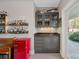 This wet bar has a mini refrigerator, granite countertops, glass cabinets, floating shelving, and a sink at 15015 Nc Hwy 73 Hwy, Huntersville, NC 28078