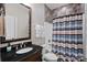 This bathroom features a dark wood vanity with black countertop, a sink, and a shower/tub combo at 15015 Nc Hwy 73 Hwy, Huntersville, NC 28078