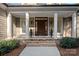Inviting front porch featuring brick steps, stately columns, and a beautifully crafted wood door at 15015 Nc Hwy 73 Hwy, Huntersville, NC 28078