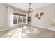 Sunlit dining area featuring light hardwood floors, large windows, and a decorative light fixture at 153 Byers Rd, Troutman, NC 28166