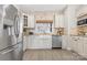 Well-lit kitchen features stainless steel refrigerator, farmhouse sink, modern appliances and light-colored cabinets at 153 Byers Rd, Troutman, NC 28166