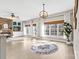 Open-plan living room with fireplace, large windows, light hardwood floors, and modern ceiling light fixture at 153 Byers Rd, Troutman, NC 28166