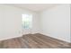 Cozy bedroom with wood-look floors and a window bringing in natural light at 1614 Arlyn Cir, Charlotte, NC 28213