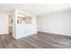 Living room view into an updated kitchen with wood-look floors at 1614 Arlyn Cir, Charlotte, NC 28213