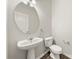 Bathroom features pedestal sink, large round mirror, and modern fixtures at 19531 Deer Valley Dr, Cornelius, NC 28031