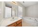 Bathroom featuring a soaking tub, shower and vanity with large mirror and sink at 19531 Deer Valley Dr, Cornelius, NC 28031