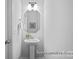 Clean and modern powder room with a pedestal sink and decorative mirror at 2302 E Main St # 1P, Albemarle, NC 28001