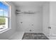 Well-lit laundry room with vinyl floors, shelving, and a window with a view of the outside at 2302 E Main St # 1P, Albemarle, NC 28001