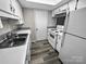 Bright kitchen features white appliances, ample cabinet space, and stainless steel double sinks at 2507 Kilborne Dr # H, Charlotte, NC 28205