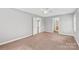 Bedroom features neutral walls, carpet, a ceiling fan, and a doorway leading to a bathroom at 2913 Ashley Woods Ct, Monroe, NC 28112