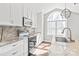 Bright kitchen boasts white cabinets, stainless steel appliances, stone countertops, and an island with a sink at 2913 Ashley Woods Ct, Monroe, NC 28112