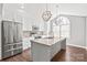 Bright kitchen featuring stainless steel appliances, a large island with a sink, and unique pendant lighting at 2913 Ashley Woods Ct, Monroe, NC 28112