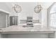 Bright kitchen shows stainless steel appliances, white cabinets, and a granite island with stylish pendant lights at 2913 Ashley Woods Ct, Monroe, NC 28112