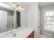 Bright bathroom with a large mirror, vanity, shower-tub combo, and a window at 307 Rose Garden Ct, Rock Hill, SC 29732