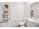 Bright bathroom featuring a white vanity with a pedestal sink, modern toilet, and decorative corner shelves at 320 Heritage Pl, Mooresville, NC 28115