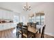 Bright dining room with wood floors, modern chandelier, and views of the screened porch at 320 Heritage Pl, Mooresville, NC 28115