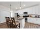 Bright kitchen featuring white cabinets, granite countertops, and stainless steel appliances with a breakfast bar at 320 Heritage Pl, Mooresville, NC 28115