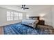 Inviting main bedroom with a large window, ceiling fan, and a cozy bed with blue accents at 320 Heritage Pl, Mooresville, NC 28115