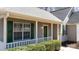 Close-up of a charming front porch with green door and shutters and neat trim, offering curb appeal at 3507 Sassafras Trl, Waxhaw, NC 28173