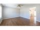 Bright living room featuring wood floors, a ceiling fan, and an open doorway leading to the entryway at 3507 Sassafras Trl, Waxhaw, NC 28173