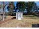Storage shed on a manicured lawn with ample space for tools and equipment, adjacent to a lush, tree-lined backyard at 3507 Sassafras Trl, Waxhaw, NC 28173